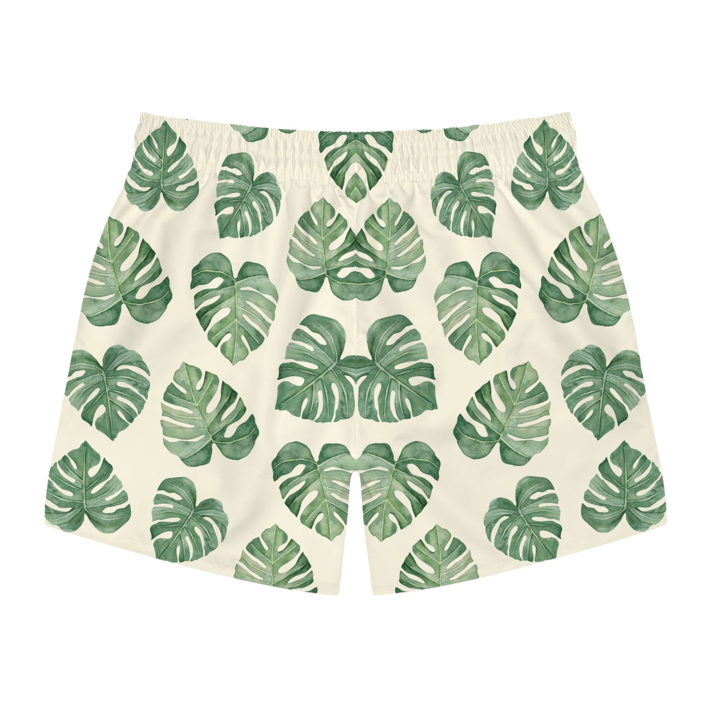 A pair of men's swimming trunks featuring an all-over green monstera leaf pattern on a warm cream background, displayed flat against a solid white background.
