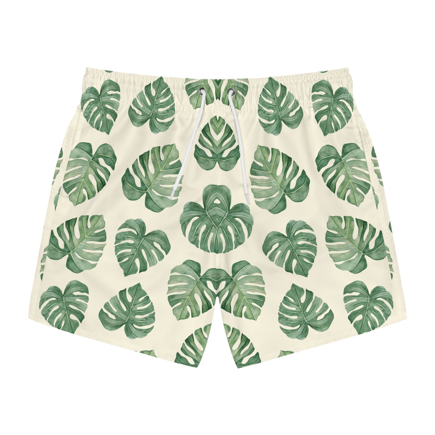 A pair of men's swim shorts featuring an all-over green monstera leaf pattern on a warm cream background, with a white drawstring at the elastic waistband.