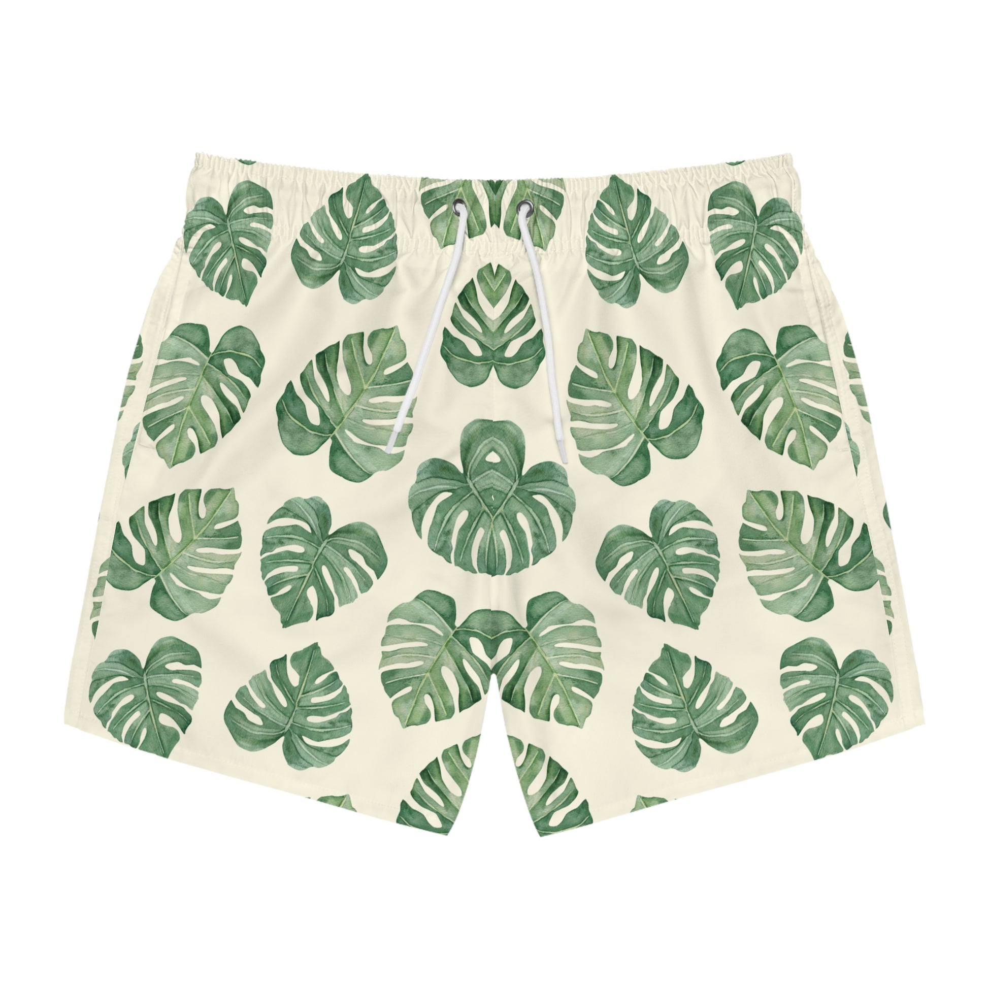 A pair of men's swim shorts featuring an all-over green monstera leaf pattern on a warm cream background, with a white drawstring at the elastic waistband.